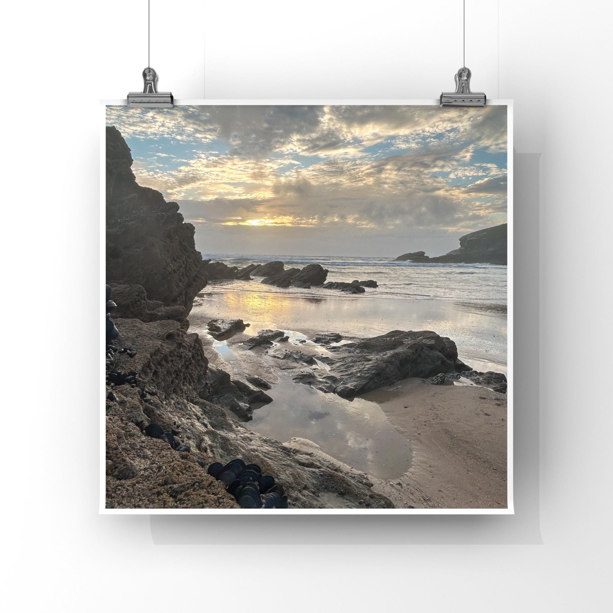 Beach scene with rocks and water, framed by a white border