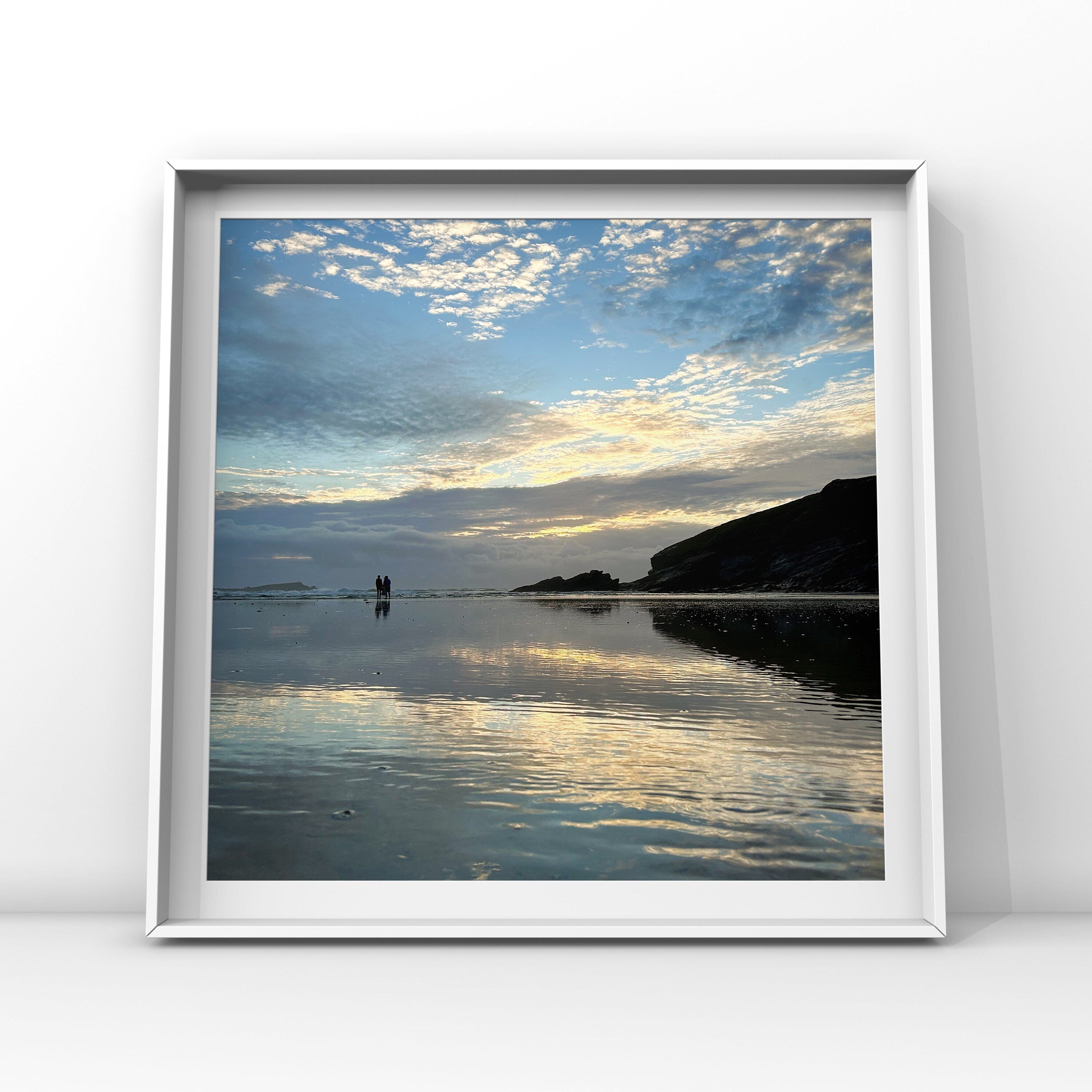 Framed artwork of a beach scene with a sunset sky reflected in wet sand