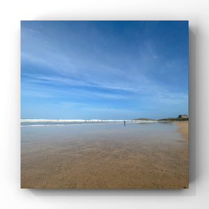 Deserted beach scene with clear blue sky and calm water