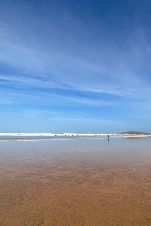 Beach scene with a vast expanse of sand, clear blue sky and calm water