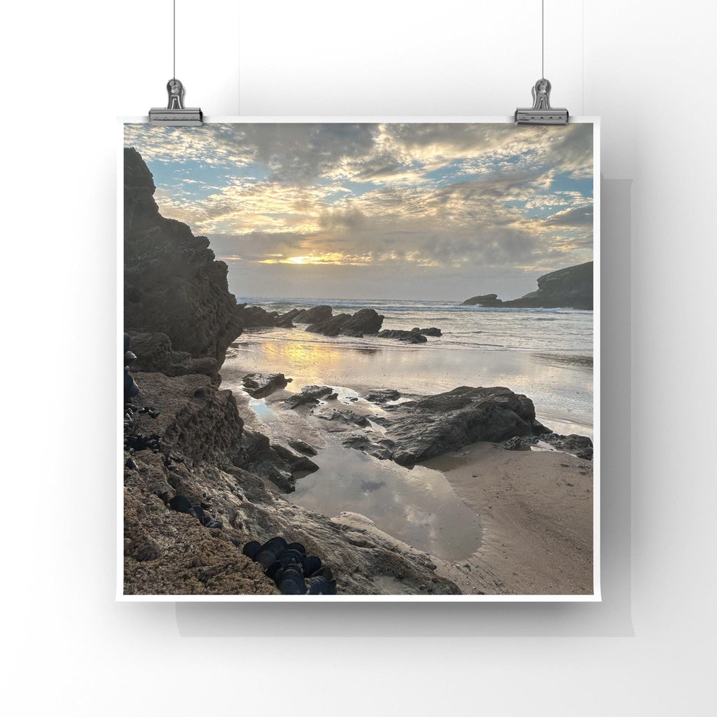 Beach scene with rocks and water, framed by a white border