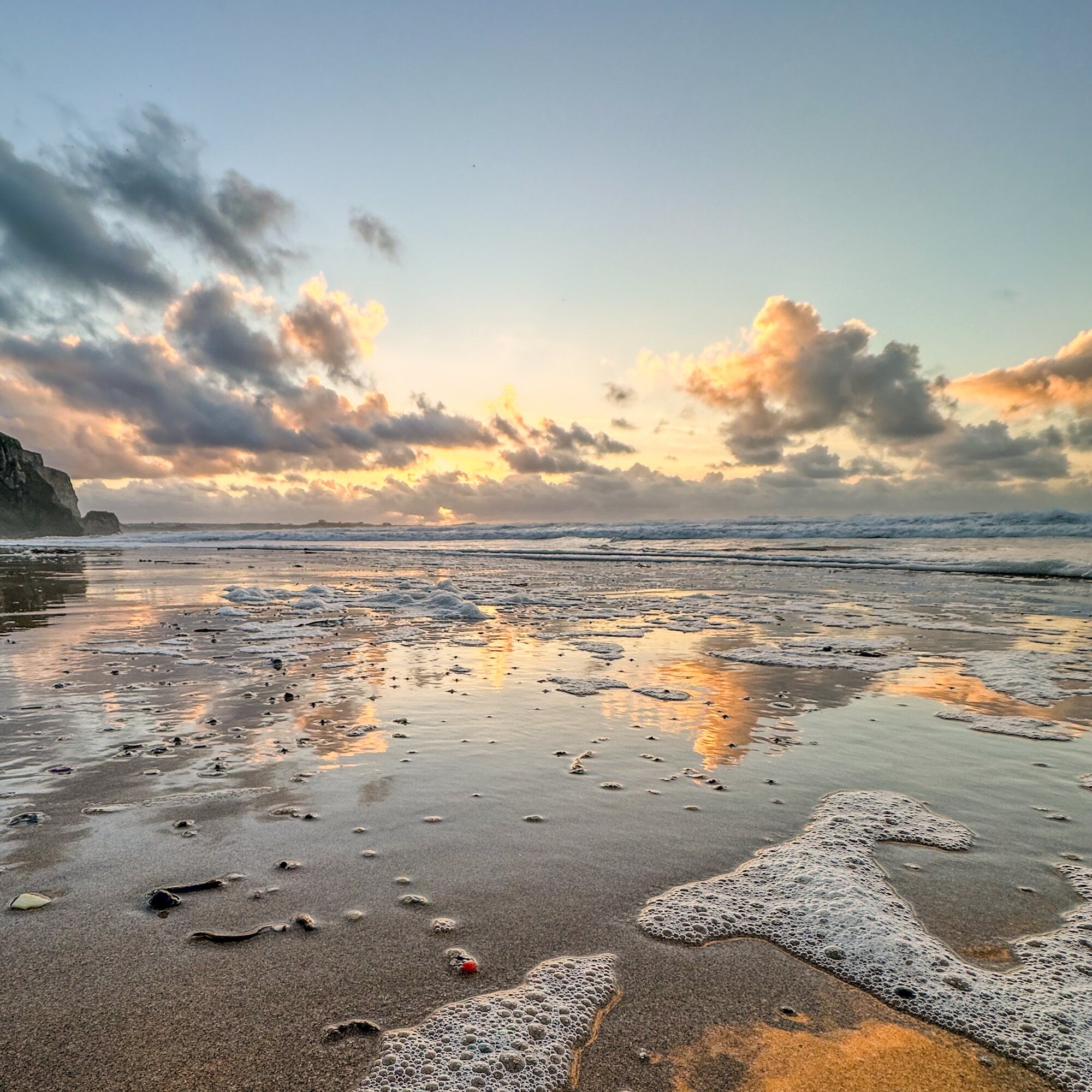 Beach scene with waves and sunset clouds